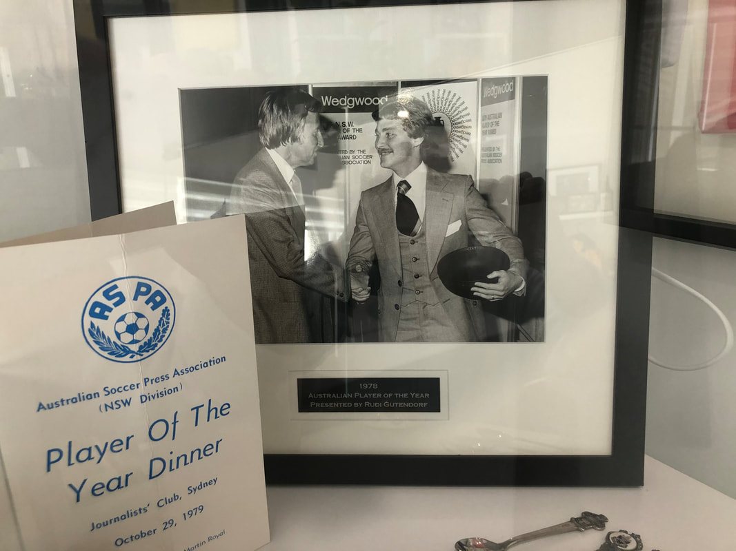 Framed photograph of Socceroos coach Rudi Gutendorf presenting Peter Stone with his Player of the Year award, beside the 1979 ASPA dinner card